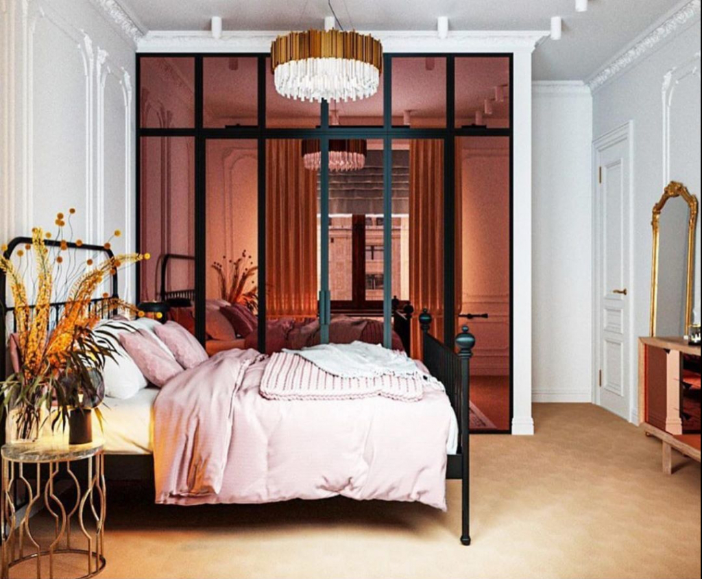 спальня с зеркальной перегородкой, металлической кроватью, стильным металлическим столиком и зеркалом в винтажной раме.jpg